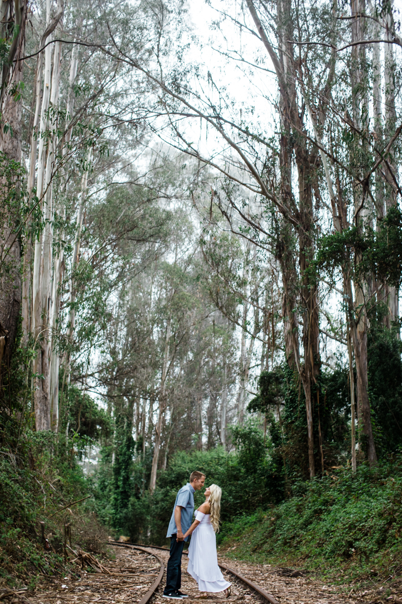 couple standing at the railroad tracks by the Eucalyptus trees