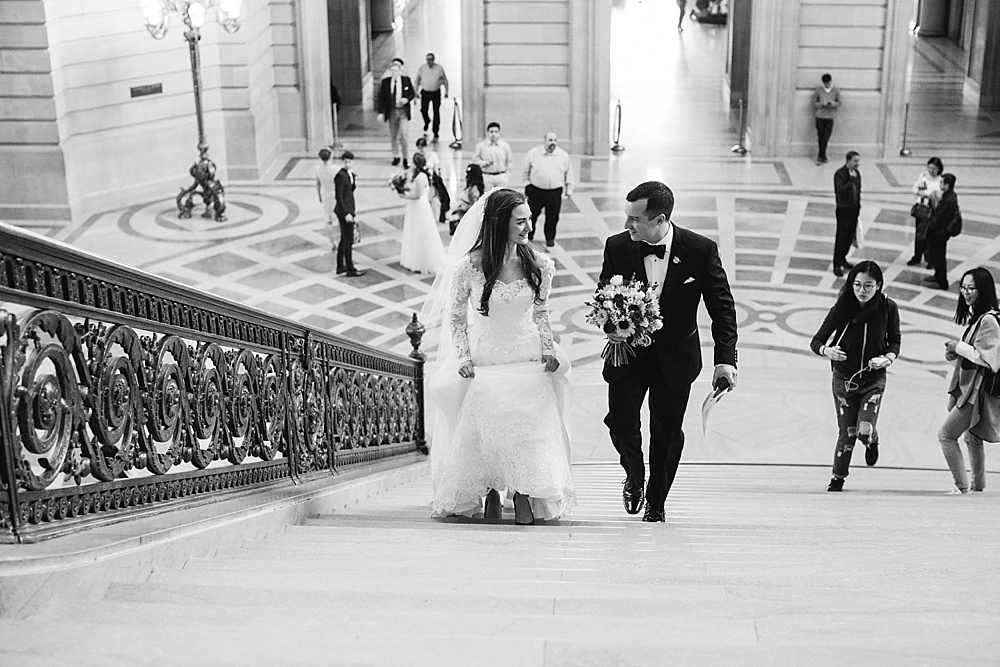Bride and groom climbing stairs at San Francisco City Hall wedding 