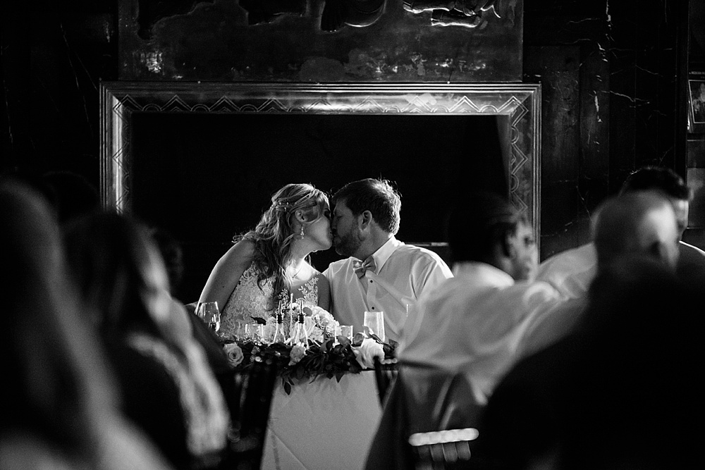 Bride and groom kiss at table at San Francisco City Club Wedding by Amy Thompson Photography