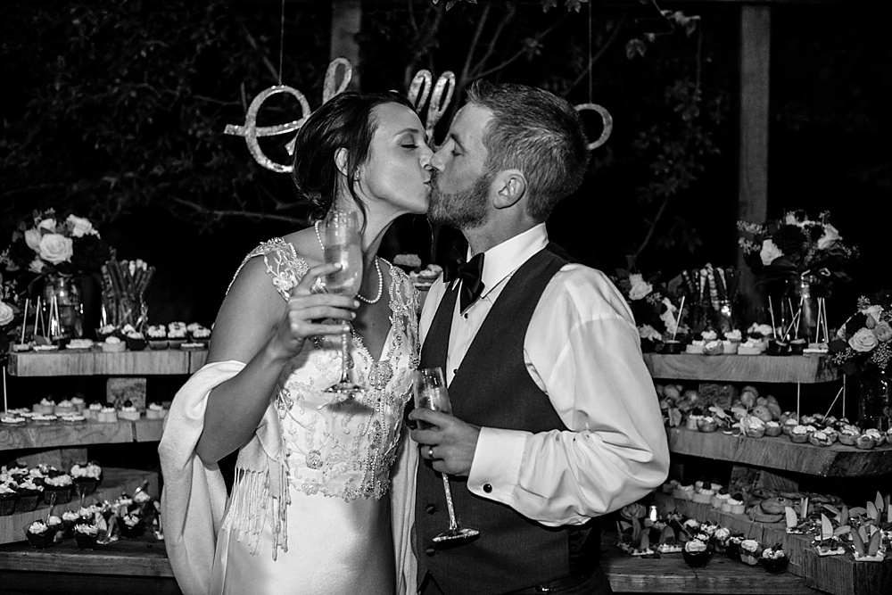 bride and groom kiss in front of dessert table at Rancho Nicasio Wedding