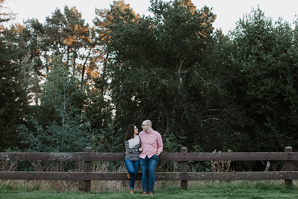 couple sitting on bench redwood regional park engagement by amy thompson photography