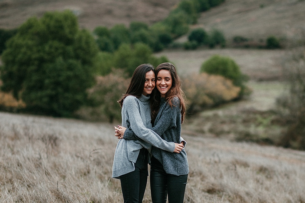 Sisters hug for outdoor family photography session by amy thompson photography