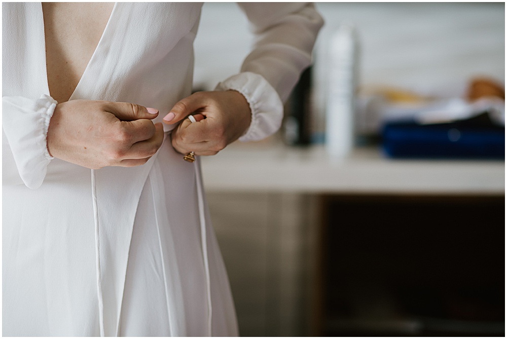 Bride putting dress on before San Francisco City Hall Wedding Ceremony by amy thompson photography