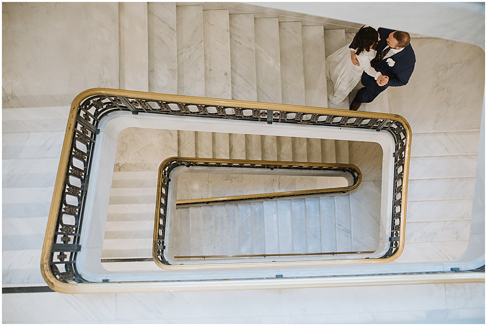 Bride and groom walk down stairs and kiss after San Francisco City Hall Wedding Ceremony by amy thompson photography