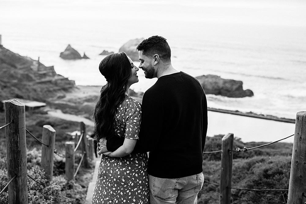 Couple kiss on top of stairs at sutro baths engagement session by amy thompson photography