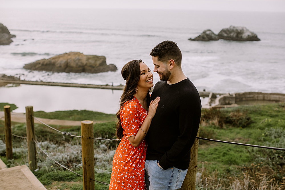 couple laugh at sutro baths engagement session by amy thompson photography