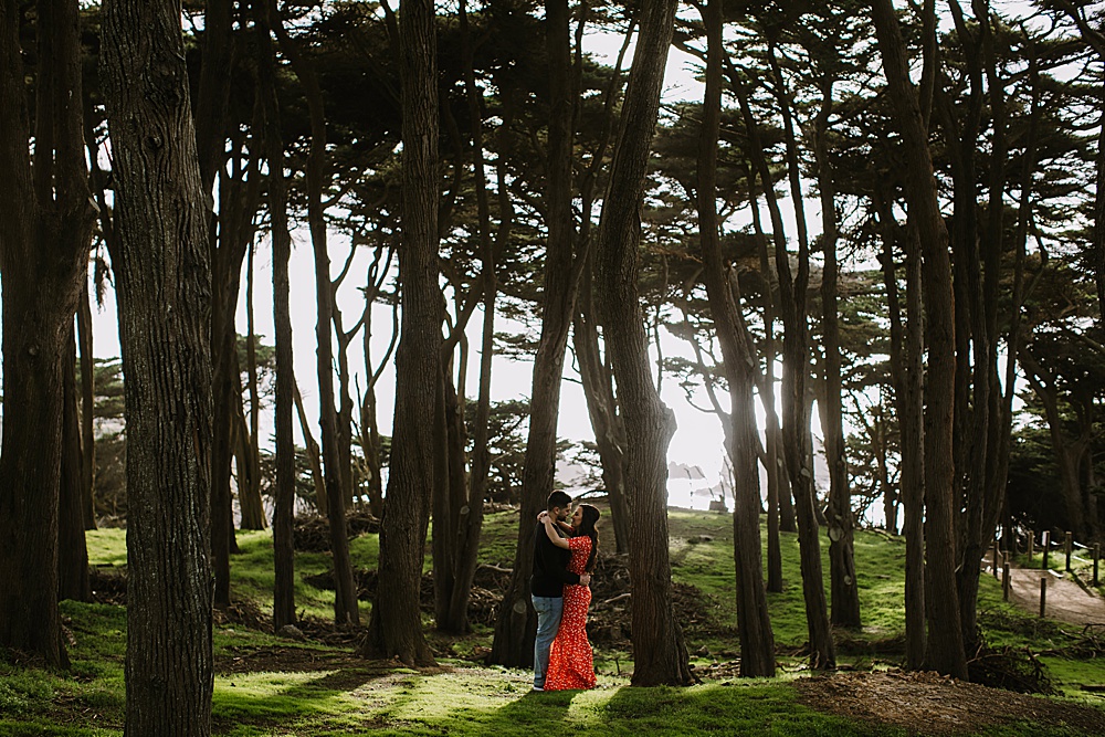 couple embrace at sutro baths engagement session by amy thompson photography