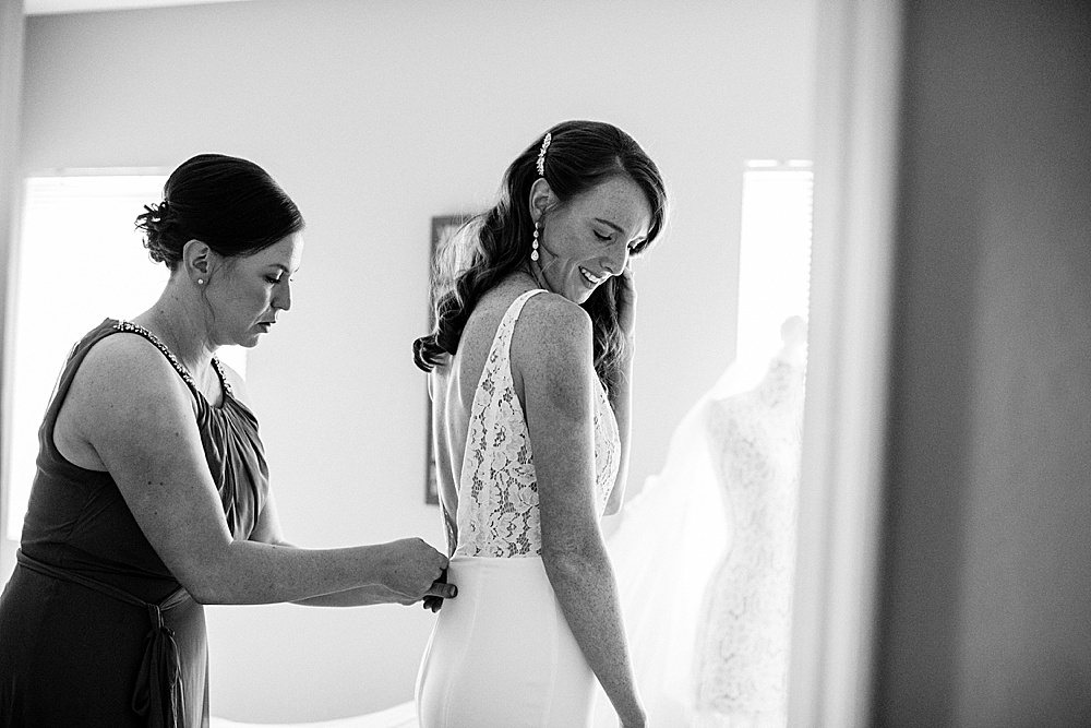 black and white of dress being zipped up at Rosewood Events by amy thompson photography