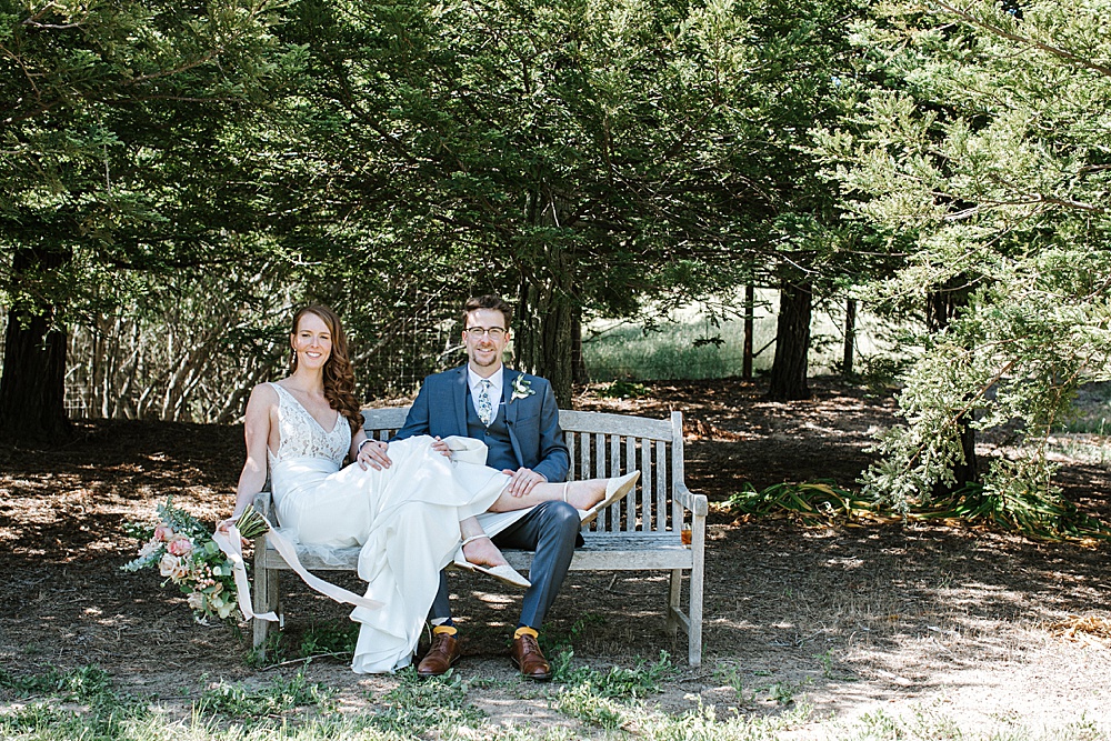 Bride and groom relax on bench at Rosewood Events by amy thompson photography