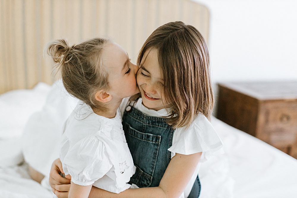 sisters being adorable for family photo shoot at home by amy thompson photography