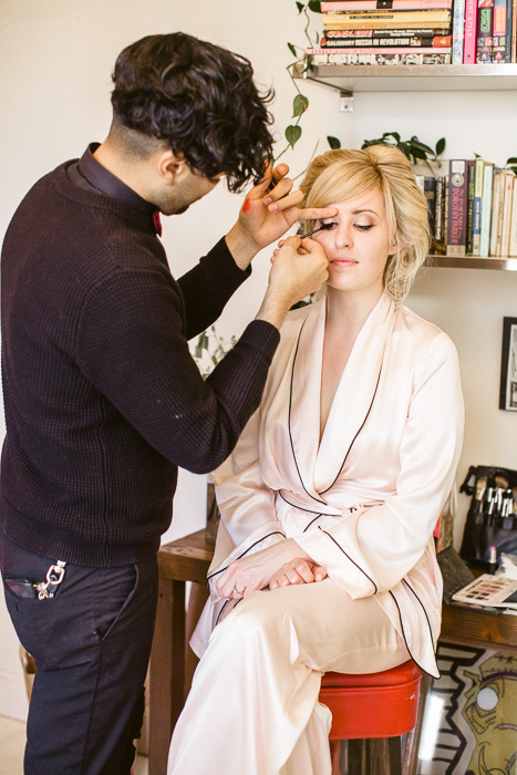bride getting make up applied by makeup artist