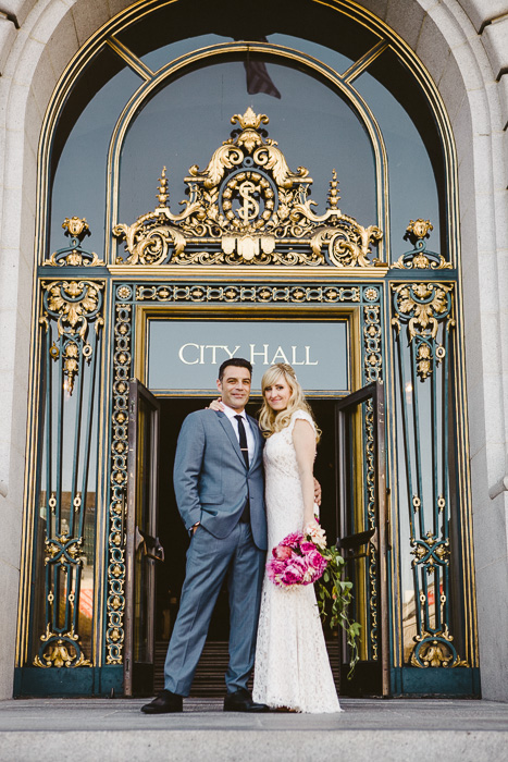 bride and groom in front of city hall doors outside