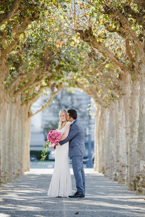 bride and groom in the archway of the trees