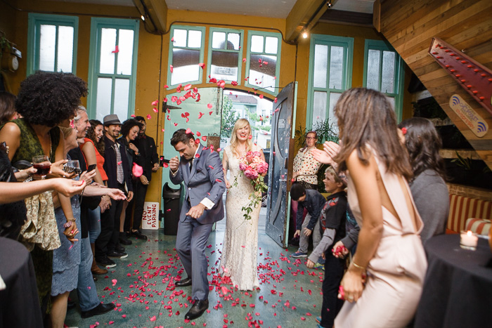 bride and groom entrance to reception with flowers being thrown
