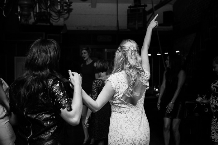 the back of bride and friend dancing