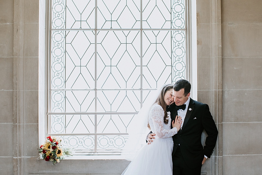 Bride and groom embrace at San Francisco City Hall wedding by Amy Thompson Photography