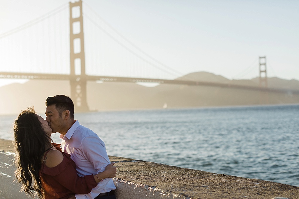 couple kiss by golden gate bridge for San Francisco Engagement Locations by amy thompson photography