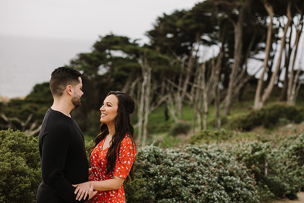 Couple looks at each other during sutro baths engagement session by amy thompson photography
